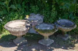 A group of four various cast reconstituted stone shallow campana urns the largest 55cm diameter x