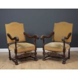A pair of 19th century Flemish oak framed open armchairs with scrolling arms and carved supports,