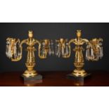 A pair of late 19th century gilt metal three branch candelabra with cut glass drops and black