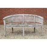 A garden bench with serpentine front and curving backCondition report: In weathered condition and