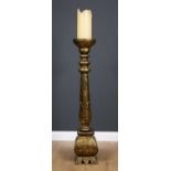 A late 20th century gilded wooden torchiere or candlestand together with a large candle, 22cm