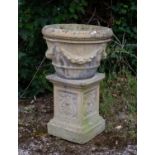 A composite stone urn, 48cm diameter x 36cm high with a matching plinth, 44cm in height together