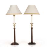 A pair of George III style mahogany and brass table lamps with fluted column supports and turned