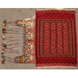 A mid to late 20th century Middle Eastern Turkmen style red ground rug 183cm x 130cm together with a