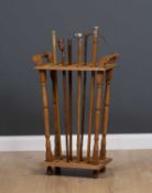 An oak stick stand for displaying walking sticks, with turned supports together with a group of