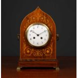 An antique French rosewood cased mantle clock the shaped case with decorative inlay, carrying