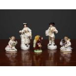 A group of decorative porcelain figurines consisting of two gardeners, two putti one with a sheep