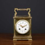 An antique French brass cased carriage type mantle clock with hinged carrying handle, the enamel