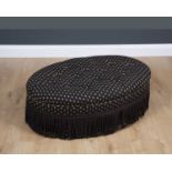 A 20th century oval upholstered stool with tassels and four mahogany square tapering legs