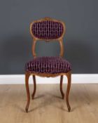 An antique French side chair with carved ornament, overstuffed upholstered back and seat and