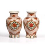 A pair of late 20th century Chinese style porcelain vases of baluster form with flaring rims and red