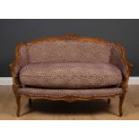 An 18th century French style walnut small sofa with purple spot upholstery and carved decoration