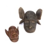 A Makonde helmet mask, Mozambique, carved wood with a grotesque face and large ears with another