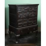 A late 17th century oak chest, of three geometrically panelled long drawers, on stand fitted with