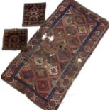 Two old Persian saddle bags with geometric decoration on a red ground, 60 x 48cm and 48 x 48cm,