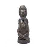 A Kuba King figure, carved wood statuette with cross legs seated on a incised geometric design base,