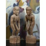 A pair of carved wooden Bullul rice divinity figures, male and female, each stooped and on a