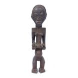 A Bembe maternity figure, Democratic Republic of Congo, wood with carved braided hair, scarification