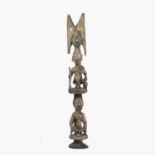 A West African Yoruba totem post, carved wood made up from stacked figures, with signs of old