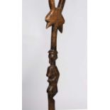 An African walking staff with stand, Songye style, carved wood, top part has a janiform bird to a