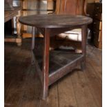 A 19th century oak cricket table, the circular top on three slightly splayed legs, with triangular