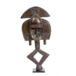 A Gabon Kota reliquary figure on stand, carved wood laid with brass and copper, 52.5cm high on