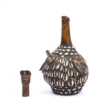 A Lega pipe, made from a gourd decorated with cowrie shells plus three carved bone face masks and