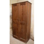 A 19th century pitch pine cupboard, having a pair of tall panelled doors enclosing shelving, 94cm