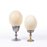 Two antique ostrich eggs displayed in metal goblets, 15cm (4)