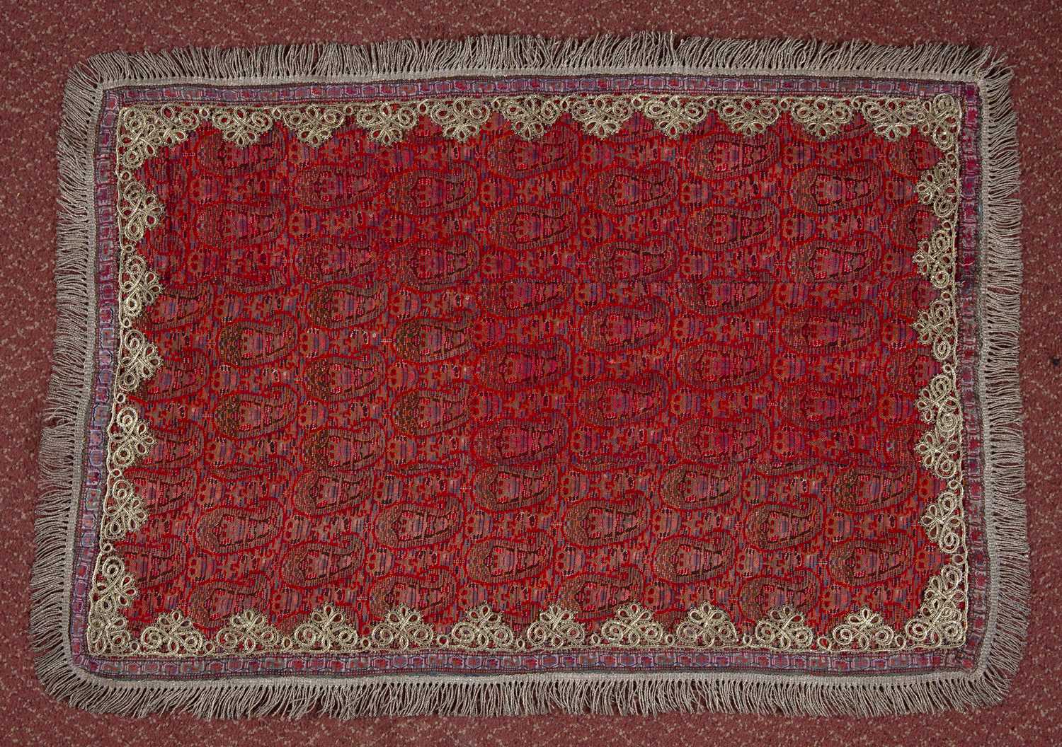 A Persian Kirman Termineh twill for a cradle with repeating boteh motif on a red ground with