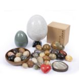A large ceramic 'ostrich' egg on stand, 30cm high, and a collection of twenty agate eggs and