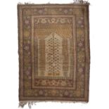 A Turkish pastel coloured rug with central foliate design within an arch and with wide borders,