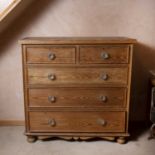 A Victorian pitch pine chest, of two short and three long drawers, with lobed glass handles, on