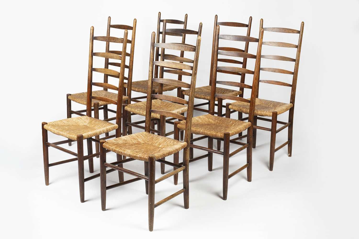 Arts & Crafts set of eight oak ladderback dining chairs with raffia seats, unmarked, 110cm high (8)