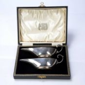 Pair of cased silver sauce boats bearing marks for Charles Weale, Birmingham, 1928, 16cm across,