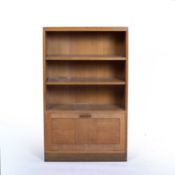 In the manner of Heals oak bookcase with three shelves above a cupboard, 67cm x 110cm x