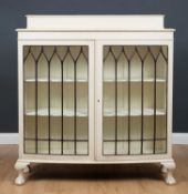 A painted bow fronted display cabinet with short cabriole legs terminating in claw and ball feet,
