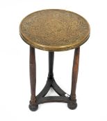 An early 20th century Oriental brass topped circular occasional table with turned supports and bun