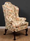 A George II style wingback armchair with floral upholstery and label for 'The Odd Chair Company'