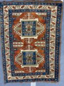 A Middle Eastern orange and blue ground rug with geometric decoration, 116cm x 150cmCondition