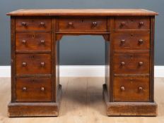 A late Victorian mahogany pedestal desk with a brown leather inset top, nine drawers with turned