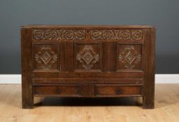 An old oak coffer with triple panelled front and standing on stile feet, 110cm wide x 46cm deep x