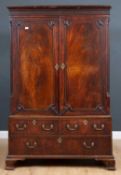 A George III linen press, with blind fretwork decorated cornice, the doors enclosing a hanging rail,