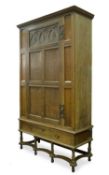 An antique oak panelled cupboard with an associated base, 126cm wide x 50cm deep x 220cm