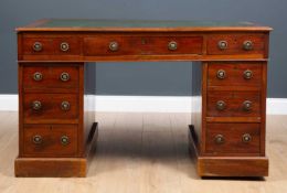 A Victorian mahogany pedestal desk with a green leather inset top, nine drawers with brass ring