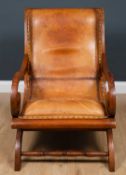 A late Victorian walnut and leather upholstered armchair with scrolling arms, 61cm wide x 80cm