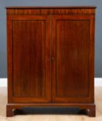 A 19th century mahogany side cabinet with twin panelled doors raised on bracket feet, 78cm wide x