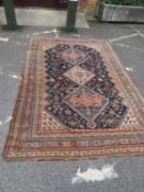An early 20th century Persian style polychrome rug with a multiple banded border, three central