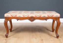A 19th century carved walnut framed upholstered stool with cabriole legs, 103cm wide x 45cm deep x