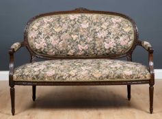 A small French style dark stained beechwood sofa with carved decoration and floral upholstery, 132cm